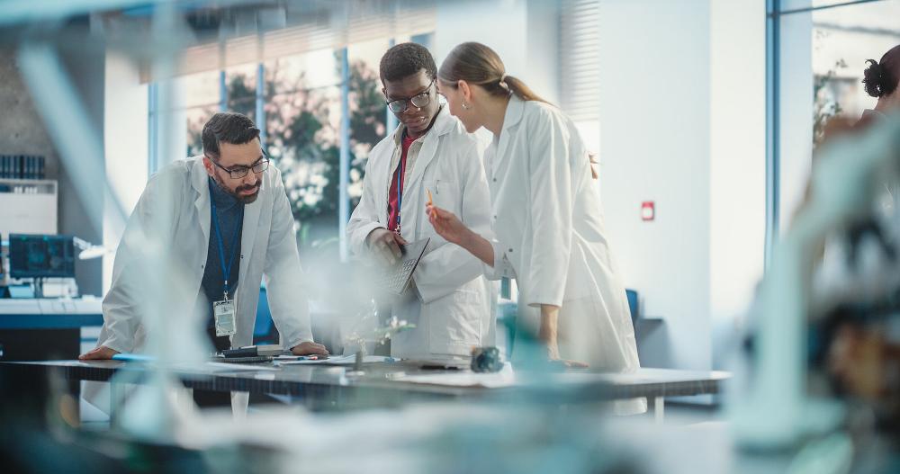 Three lab workers around the table